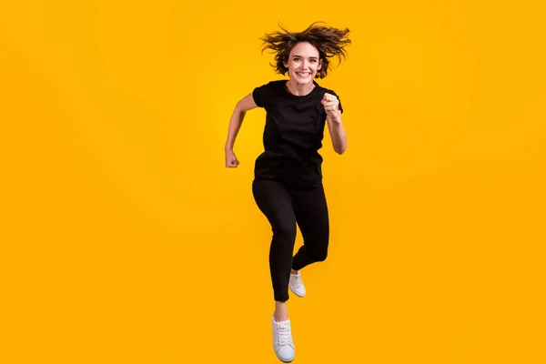 Teljes hossz testméret kilátás szép sportos vidám céltudatos lány ugrás futó elszigetelt élénk sárga színű háttér — Stock Fotó