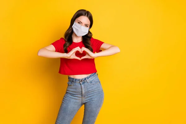 Foto van positieve meisje maken vingers hart tonen hartstochtelijke liefde teken slijtage masker geïsoleerd over heldere glans kleur achtergrond — Stockfoto