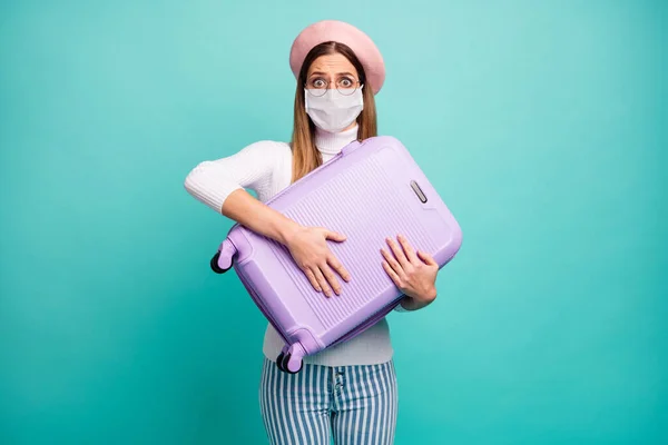 Foto de senhora abraço grande mala violeta medo desgaste máscara especificações rosa boina branca gola alta listrada jeans isolado cor teal fundo — Fotografia de Stock