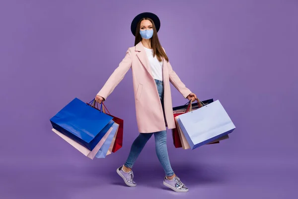 Full length photo of trendy girl hold many bags shopping mall wear mask trend outfit isolated over purple color background — Stock Photo, Image