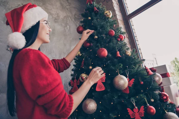 원문 기사보기 여자 아이의 모습을 찍은 사진에는 산타 클로스 모자를 쓰고 크리스마스 트리를 실내에서 크리스마스 장식을 하고 있다. — 스톡 사진