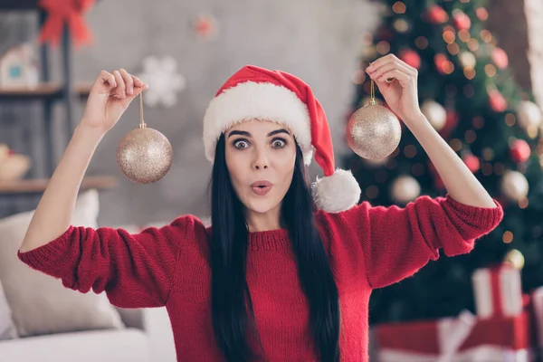 Noel Baba başlıklı hayretler içinde bir kız. Evin içinde iki takı tutuyor. Noel Baba atmosferinde sihirli süslemeleri var. — Stok fotoğraf