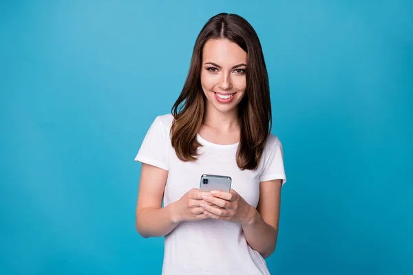 Portret pozytywnej wesołej dziewczyny używać smartfona śledzić post komentarz social media aktualności nosić dobry wygląd ubrania izolowane na tle niebieskiego koloru — Zdjęcie stockowe