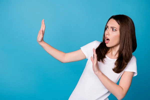 Fotografie nervózní dívka držet ruku vzhled copyspace křik stop dont přesunout nosit ležérní styl outfit izolované přes modré barvy pozadí — Stock fotografie