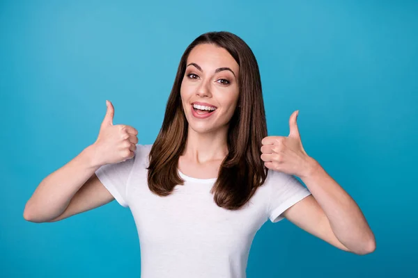 Portrait of positive cheerful girl showing thumb up demonstrate advert promotion wear good look clothes isolated over blue color background