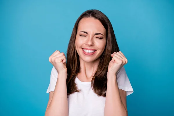 Ja, hoor. Close-up foto van aantrekkelijke grappige dame ogen gesloten goed humeur charmante schattig uiterlijk verhogen vuisten verbaasd prestatie dragen casual wit t-shirt geïsoleerde blauwe kleur achtergrond — Stockfoto