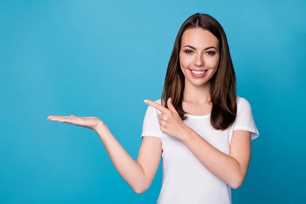 Foto de encantadora señora bastante atractiva buen humor mantenga abierta el brazo de la palma que muestra el dedo directo presentando novedad precio bajo venta producto desgaste blanco camiseta aislado color azul fondo — Foto de Stock