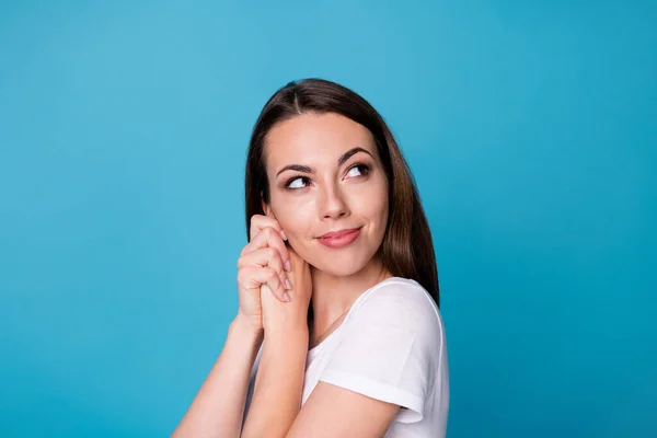 Foto de perfil de primer plano de atractiva dama linda encantadora sostener los brazos cerca de las mejillas cara radiante sonrisa llena de alegría mirar de lado hacia arriba espacio vacío desgaste casual camiseta blanca aislado color azul fondo — Foto de Stock