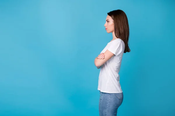 Foto de perfil de atractiva señora confiada brazos cruzados jefe trabajador exitosa carrera mirada lado vacío espacio expresión seria desgaste casual camiseta blanca jeans aislados color azul fondo —  Fotos de Stock