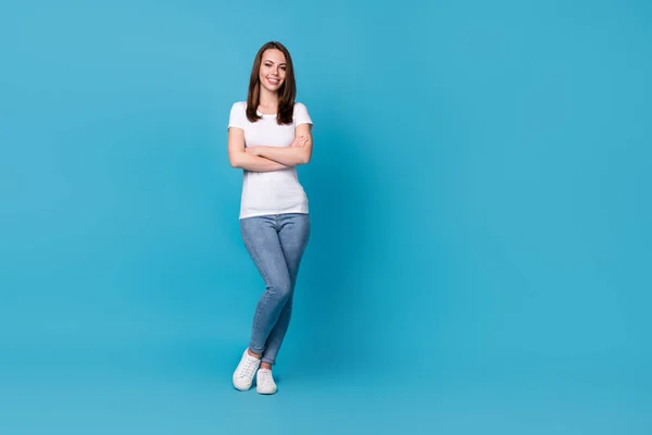 Full body foto van aantrekkelijke dame houd armen gekruist succesvolle carrière vrouw manager zelfverzekerd persoon dragen casual witte t-shirt jeans sneakers geïsoleerde blauwe kleur achtergrond — Stockfoto