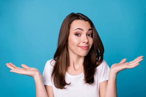 Primeros planos foto de atractiva dama indiferente sostener los brazos manos hacia arriba hombros encogiéndose de hombros no se siente culpable lo siento mala persona descuidado desgaste casual blanco camiseta aislado color azul fondo — Foto de Stock