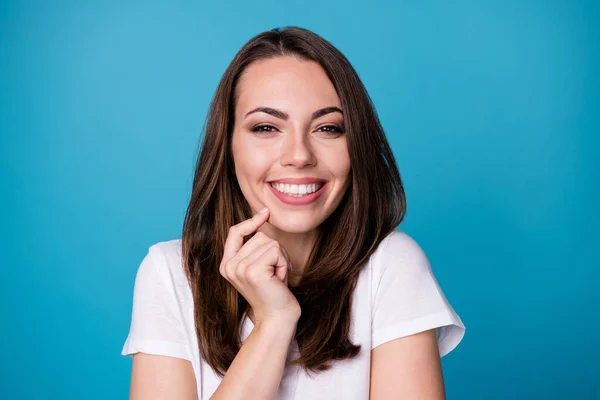 Närbild foto av attraktiv rolig dam gott humör charmigt utseende ser flickaktigt uttryck på kameran finger på hakan kind bära casual vit t-shirt isolerad blå färg bakgrund — Stockfoto