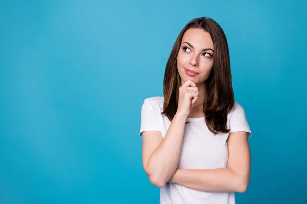 Foto van aantrekkelijke charmante zelfverzekerde dame houd arm op kin look flirterig omhoog lege ruimte denken sluwe ogen creatief intelligent persoon dragen casual wit t-shirt geïsoleerde blauwe kleur achtergrond — Stockfoto