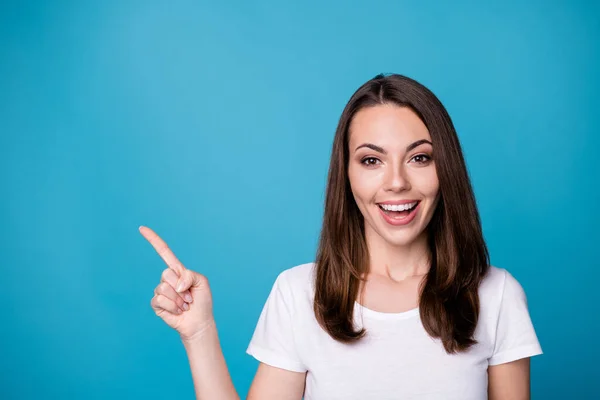 Primo piano foto di attraente divertente signora buon umore dirigendo le dita lato spazio vuoto che presenta novità banner sconto prezzi indossare casual bianco t-shirt isolato colore blu sfondo — Foto Stock