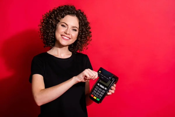 Foto av ganska söt vågig dam klädd casual svart outfit betala terminal trådlöst kreditkort isolerad röd färg bakgrund — Stockfoto