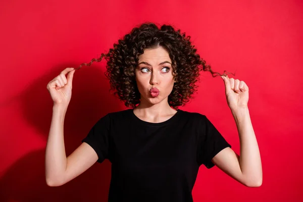 Close-up ritratto di bella ragazza dai capelli ondulati toccare labbra broncio capelli sani isolati su sfondo di colore rosso brillante — Foto Stock