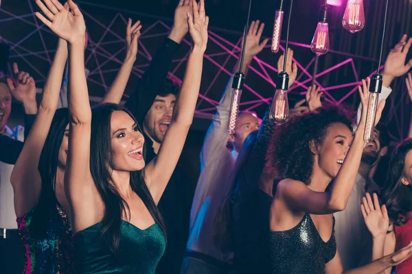 Foto de uma jovem empresa comemorando juntos o ano novo na festa no clube dançando mantendo as mãos para cima — Fotografia de Stock