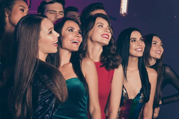 Фото компании друзей, улыбающихся, позирующих вместе для фото в ночном клубе, празднующем новый год на корпоративной вечеринке — стоковое фото