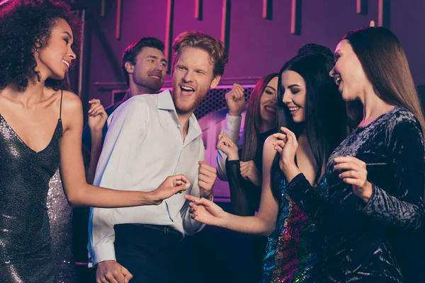 Foto van vrienden bedrijf ontspannen in nachtclub lachen grappen dragen feestelijke modieuze kleding dansen samen op de vloer met neon lichten — Stockfoto