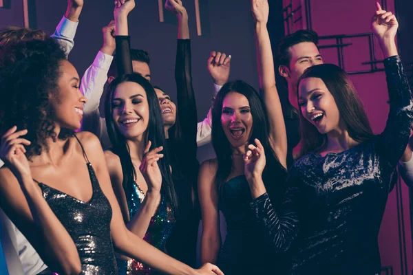 Фото дівчат компанія танцює в нічному клубі з неоновими вогнями, святкуючи новий рік разом, охолоджуючи розслаблюючі в модних сукнях — стокове фото