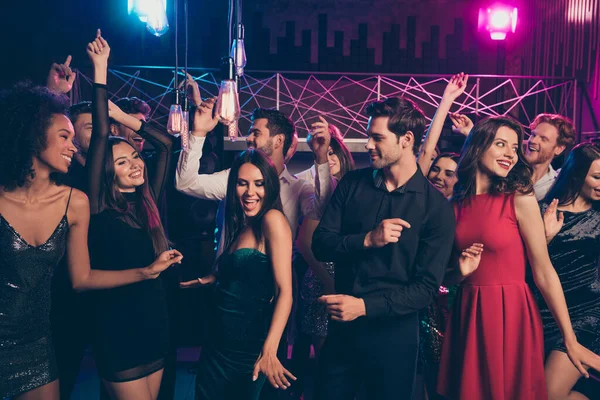 Retrato fotográfico de personas alegres y excitadas bailando juntas en una fiesta de lujo con luces de neón rosa y azul —  Fotos de Stock
