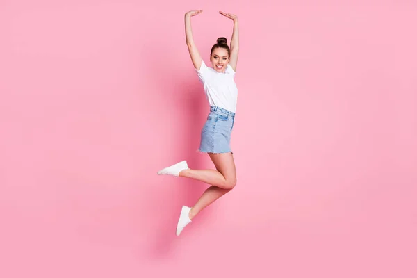 Foto de perfil de cuerpo completo de atractiva señora divertida bastante moño vacaciones de verano buen humor saltar alto vuelo de ensueño llevar camiseta blanca mini falda zapatos aislados de color rosa de fondo — Foto de Stock