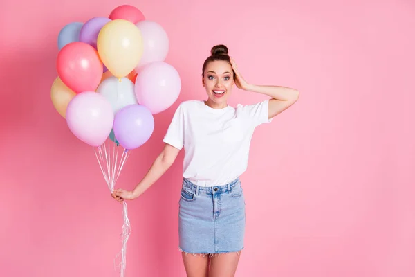 Foto van aantrekkelijke charmante dame mooie broodje zomervakantie houden veel luchtballonnen blij onverwachte verjaardag vrienden regelen dragen witte t-shirt mini rok geïsoleerde roze kleur achtergrond — Stockfoto