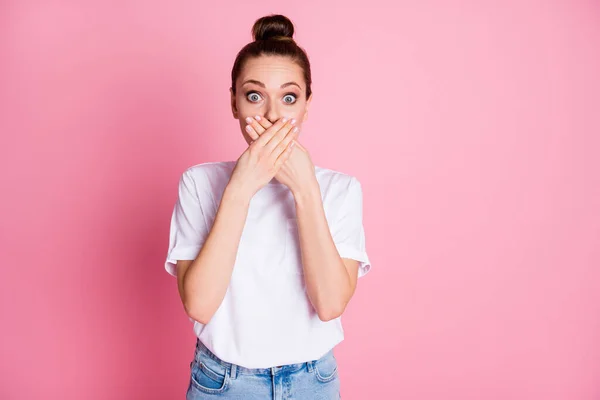 Photo of attractive shocked lady bun hairdo closing arms mouth said wrong thing made mistake big terrified fear eyes wear white t-shirt isolated pastel pink color background — Zdjęcie stockowe