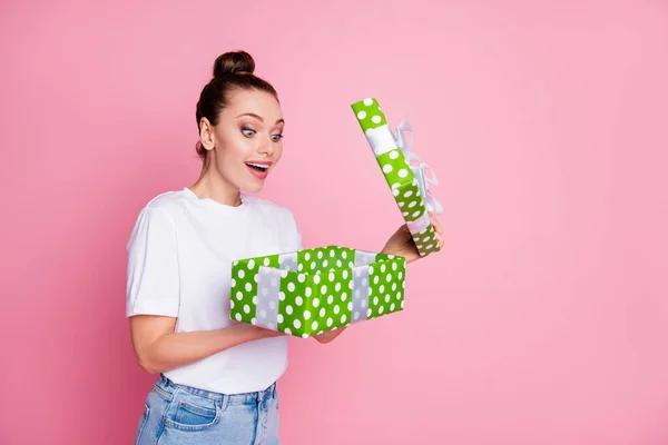 Vände foto av förvånad positiv flicka öppen dröm paket stora gröna prickade presentförpackning imponerad slitage casual stil kläder isolerad över rosa färg bakgrund — Stockfoto