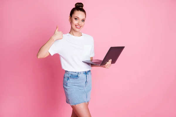 Foto di positivo ragazza lavoro uso remoto laptop raccomandare spettacolo pollice segno indossare bianco t-shirt jeans denim isolato su sfondo di colore pastello — Foto Stock