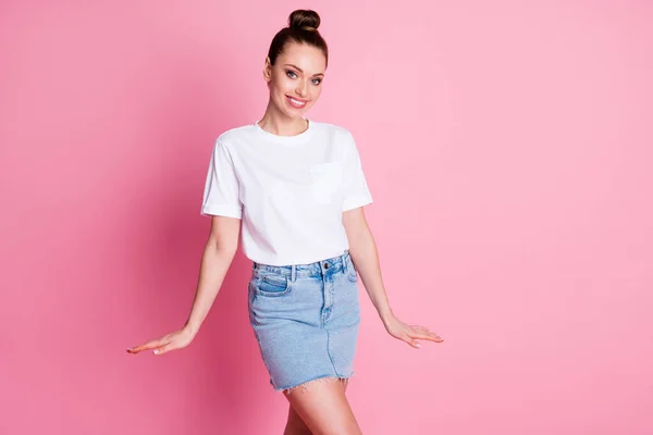 Foto de atraente encantador senhora engraçado bonito bun verão férias bom humor rua olhar andar desgaste branco t-shirt jeans azul mini-saia isolado pastel cor rosa fundo — Fotografia de Stock