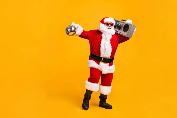 Full length photo of funky santa claus with grey beard hold boom box disco ball x-mas christmas jolly holly eve time party wear headwear red cap isolated yellow color background — Stock Photo, Image