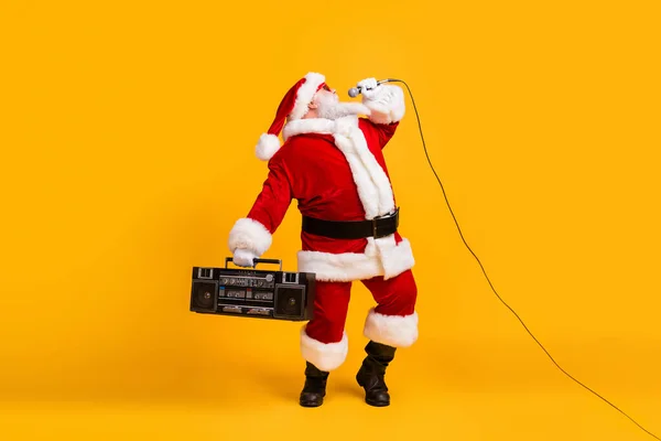 胖胖的白发苍苍的大胡子桑塔 · 克洛斯唱着圣诞圣诞歌曲，头戴帽子，与明亮的色彩背景隔离在一起 — 图库照片