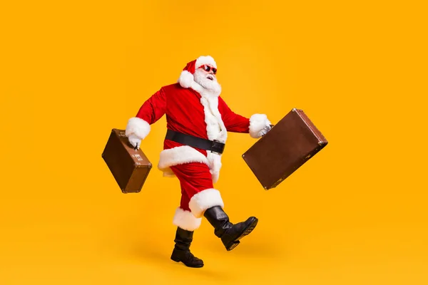Beyaz gri saçlı, sakallı Noel Baba 'nın tam boy profil fotoğrafı bavul, kopyacı uzay x-noel tatili başlık, güneş gözlüğü, parlak, parlak bir arka plan. — Stok fotoğraf
