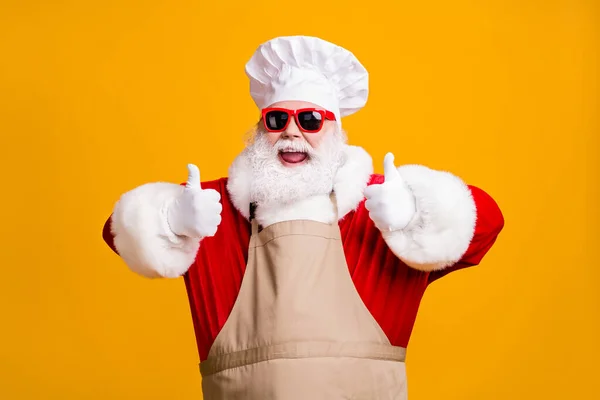 Crazy santa claus with beard in chef headwear cook show thumb up sign x-mas christmas holly jolly feast cooking wear apron sunglass isolated bright shine color background — Stock Photo, Image