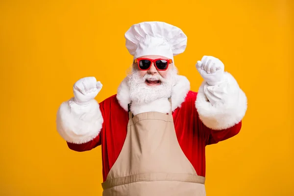Photo of crazy santa claus with beard raise fists win tradition x-mas christmas advent lottery wear chef cap sunglass apron isolated bright shine color background — Stock Photo, Image