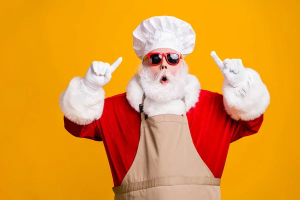 Photo of amazed santa claus point index finger chef hat christmas x-mas holly jolly meal preparation wear sunglass apron isolated over bright shine color background — Stock Photo, Image