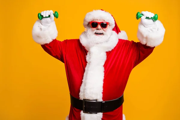 Portret van zijn hij mooi aantrekkelijk vrolijk blij Kerstman genieten van workout tillen gewicht kleine halters geïsoleerd helder levendig glans levendig geel kleur achtergrond — Stockfoto