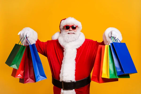 Portrait of his he nice attractive cheerful cheery fat Santa holding in hands carrying things buyings retail store boutique black Friday isolated bright vivid shine vibrant yellow color background — Stock Photo, Image