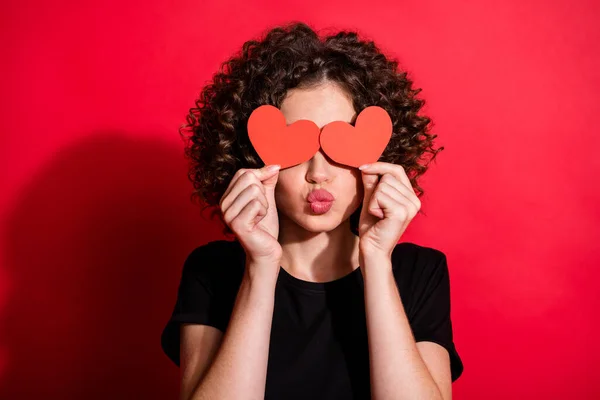 Foto de atraente encaracolado penteado pessoa mãos tampa olho coração papel figura isolada no fundo cor vermelha — Fotografia de Stock