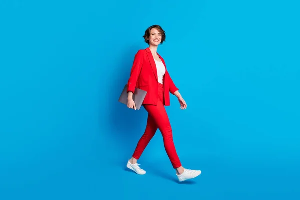 Pleine longueur vue de la taille du corps d'attrayant spécialiste femme d'affaires gaie aller portant ordinateur portable isolé sur fond de couleur bleu vif — Photo