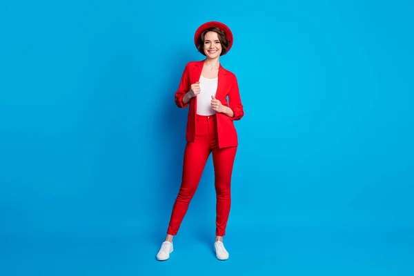 Tamanho do corpo de comprimento total vista de senhora alegre atraente vestindo roupas de terno vermelho acolhedor posando isolado sobre fundo de cor azul brilhante — Fotografia de Stock