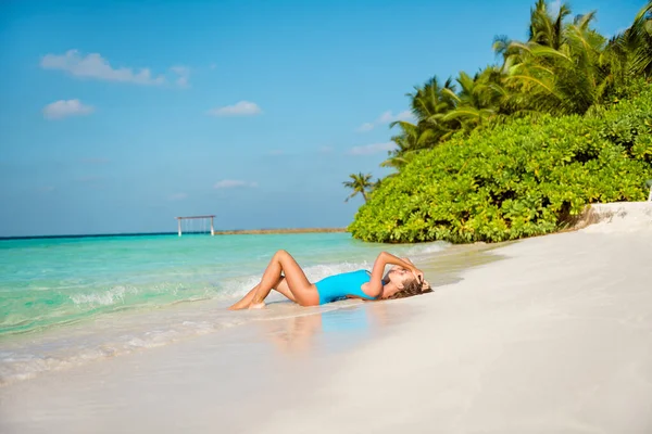 Foto in voller Größe von fit schlank gebräuntes Mädchen genießen Wochenende exotische Bucht Lagune Wochenende liegen Sand Sonnenbad tragen blauen Body Anzug — Stockfoto
