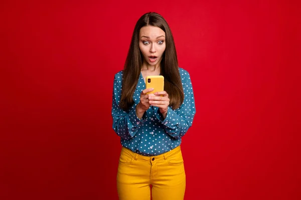 Retrato de atraente focada menina preocupada usando gadget web service falso notícias feedback isolado cor vermelha brilhante fundo — Fotografia de Stock
