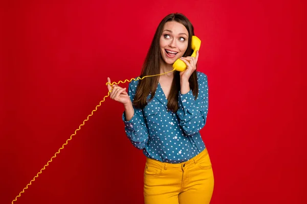 Retrato de linda menina alegre falando receptor de auscultador chamando amigo isolado no fundo de cor vermelha brilhante — Fotografia de Stock