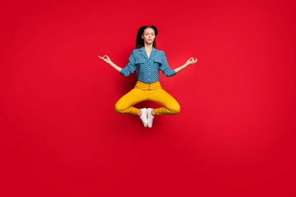 Plná délka tělo velikost pohled na pěkný klid soustředěný dívka skákání posezení lotos póza ukazující om znamení meditace izolované jasně červené barvy pozadí — Stock fotografie
