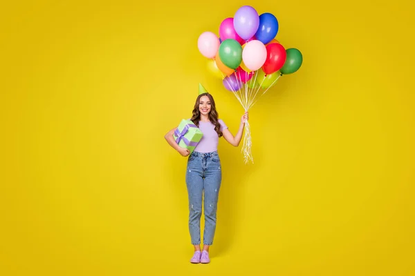 Longitud completa vista del tamaño del cuerpo de bastante alegre chica de pelo ondulado sosteniendo bolas de racimo felicitaciones aislado de color amarillo brillante fondo — Foto de Stock