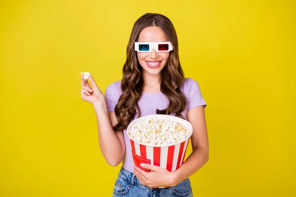 Portrait de magnifique gaie fille aux cheveux ondulés manger du maïs regarder le film temps libre isolé sur fond de couleur jaune vif — Photo