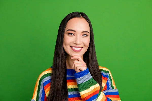 Close-up portret van mooie inhoud vrolijk meisje dragen gestreepte trui aanraken kin geïsoleerd over helder groene kleur achtergrond — Stockfoto