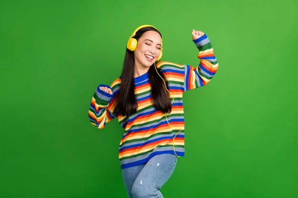 Portrait d'attrayant gai fille rêveuse profitant de l'écoute mélodie danse isolé sur fond vert vibrant couleur — Photo